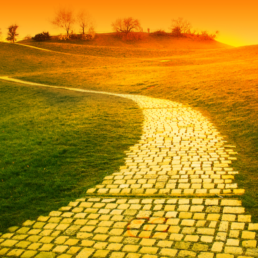 Orange sunset over hill with paved a yellow brick road